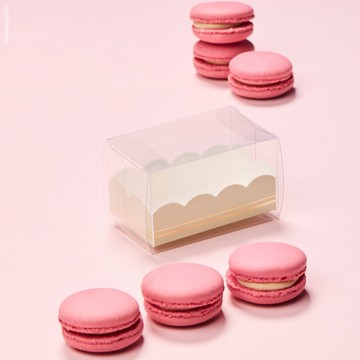 Scatola porta macarons vuota con 3 macarons rosa in fila di fronte e tre dietro